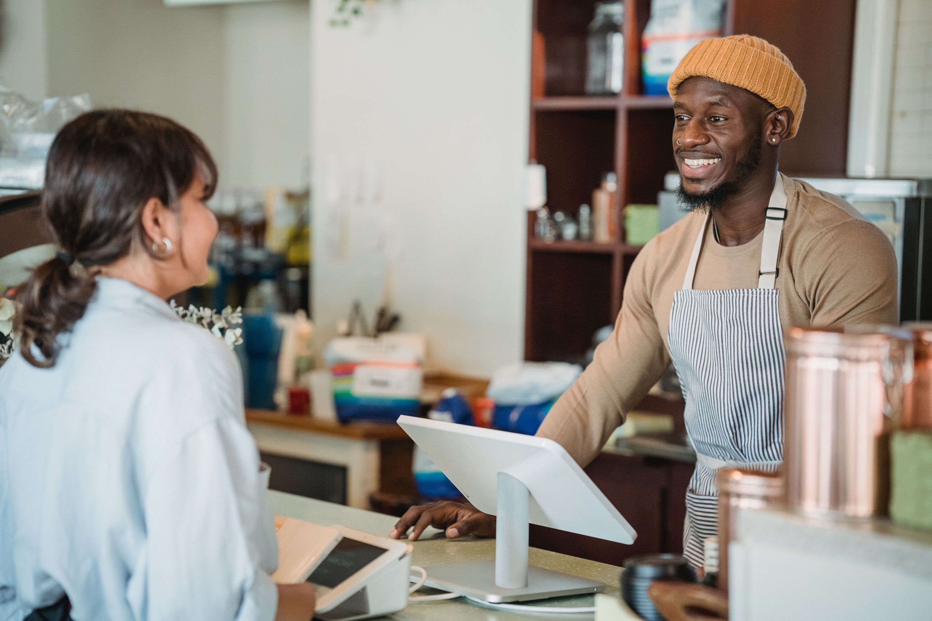 A cafe barista showing a customer the till at checkout
